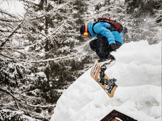 Person macht Kickflip mit Snowboard