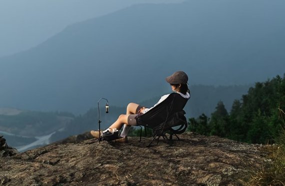 Person sitz auf Campingstuhl in den Bergen