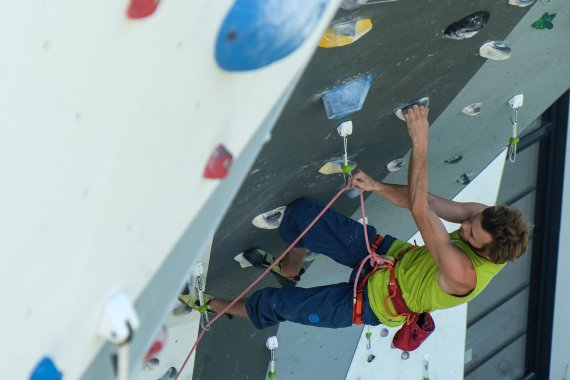 A man climbing in a boulder hall. 