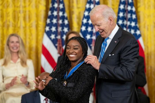 Simon Biles lacht, während sie von Joe Biden die Presidential Medal of Freedom verliehen bekommt