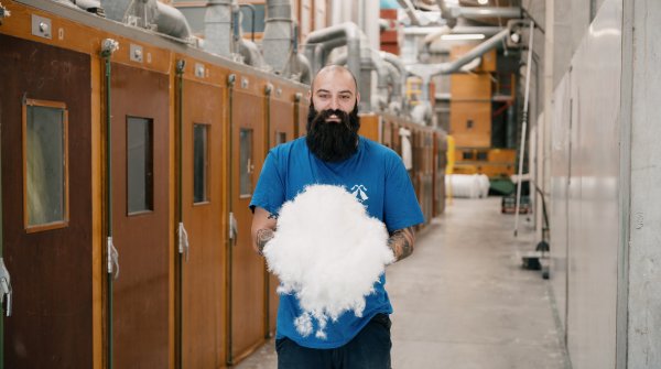 Mann hält recyclete Daunen in den Händen